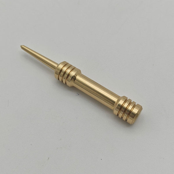 Close-up of a solid brass barbell divot tool showing the tapered prong and machined grip rings