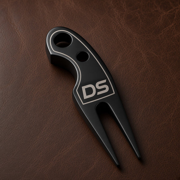 Black Trapper divot tool engraved with a DS monogram and border, on brown leather