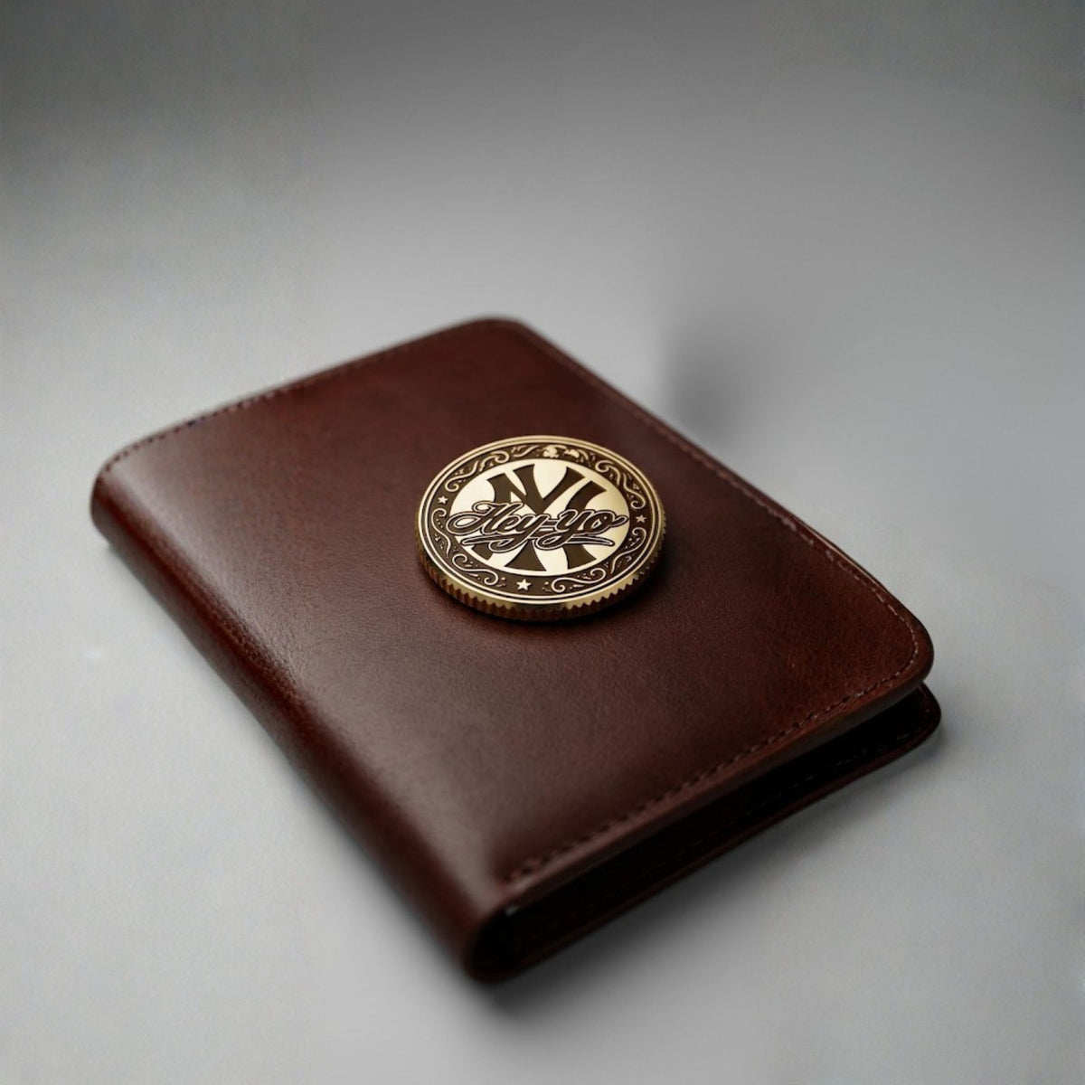 Engraved brass golf ball marker on a brown leather wallet