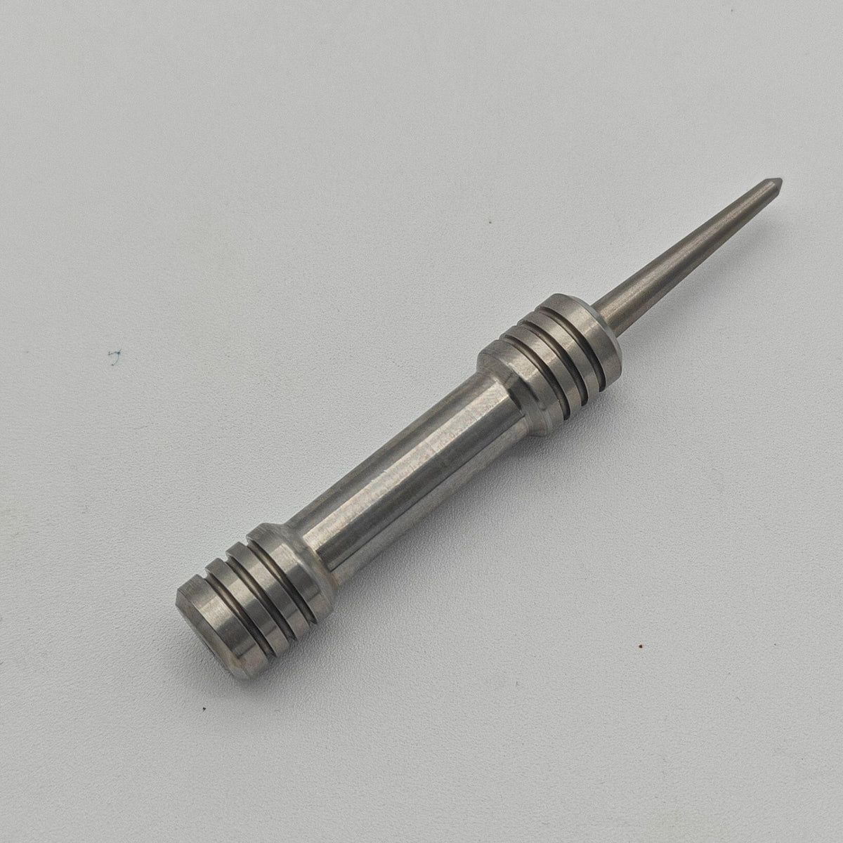 Close-up of a stainless steel barbell divot tool single prong and grip rings