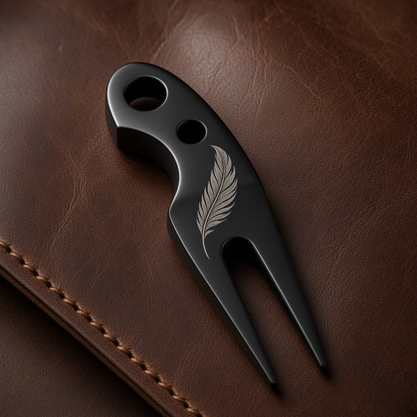 Black Trapper divot tool engraved with a feather design, on a brown leather wallet